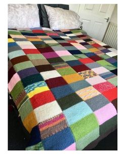 a multicolored blanket sitting on top of a bed