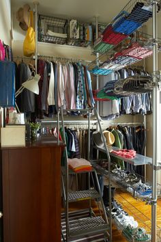 an organized closet with clothes, shoes and other items hanging on the wall next to it