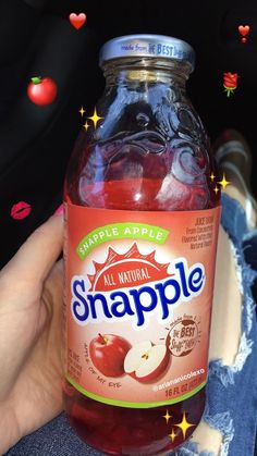 someone holding up a bottle of snapple with apples in it's back pocket