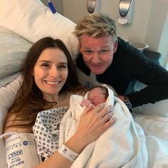 a man and woman holding a baby in a hospital bed