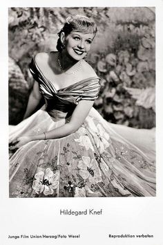 a black and white photo of a woman in a dress