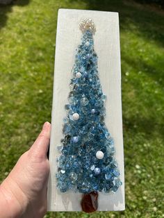 a small blue christmas tree made out of glass beads