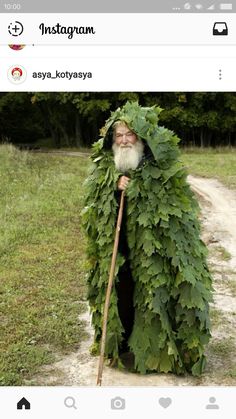 a man dressed up like a leaf with a stick in his hand and wearing a costume made out of leaves