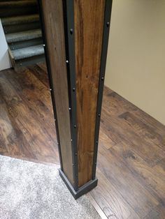 a tall wooden tower sitting on top of a hard wood floor next to a stair case