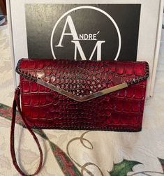 André M's red leather clutch in embossed faux leather is ideal for an evening cocktail or party. With its double loop laced edge and gold toned metal edging, this red evening clutch purse enhances your romantic and provocative style. Definitely classy and chic. Redesigned so you can use it as a clutch or wristlet. Lined leather interior Three card slots - can hold six or more cards Fits all phone sizes Water resistant Easily cleaned with a damp cloth 9.5" X 5"  2" wide at top when open Each clutch is meticulously handcrafted by me, ensuring your style is as unique as you are. Elevate any occasion with this colorful and distinctive red clutch, adding a touch of elegance to your red, black, or gold outfit. It's the the perfect purse for all occasions! Ideal for cocktail and parties, weddings Evening Clutch With Card Slots In Pouch Shape, Red Pouch Clutch With Card Slots, Red Clutch With Card Slots, Chic Evening Clutch With Card Slots, Red Clutch With Removable Pouch For Party, Red Clutch Wallet For Formal Occasions, Red Leather Clutch For Party, Red Formal Bag With Card Slots, Red Leather Evening Wallet