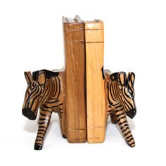 two zebra figurines sitting next to each other on top of a bookshelf