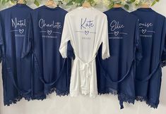 blue robes hanging on a wall with white flowers and greenery in the back ground