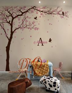 a child's room with a tree and birds painted on the wall