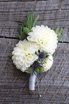 a bouquet of white flowers sitting on top of a wooden table