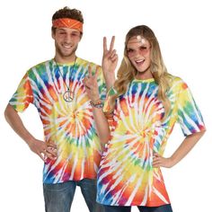 a man and woman in tie dye shirts making the peace sign