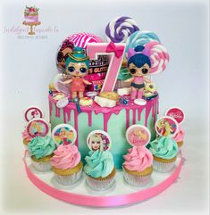 a birthday cake with cupcakes and lollipops on the top tier