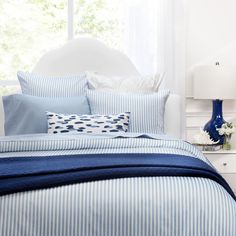 a bed with blue and white striped sheets