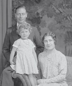 an old black and white photo of two adults and a child