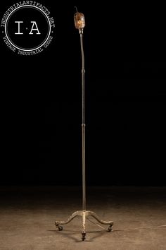 an old fashioned floor lamp on wheels in the dark