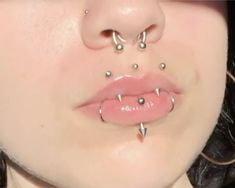 a woman with piercings on her nose and tongue