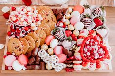 a wooden platter filled with lots of different types of cookies and desserts on top of it