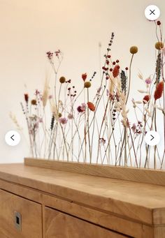 a wooden table topped with lots of flowers and arrows pointing to different locations on the wall