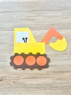 a paper construction vehicle cut out on top of a wooden table