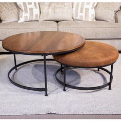 two coffee tables sitting on top of a rug in front of a couch and loveseat