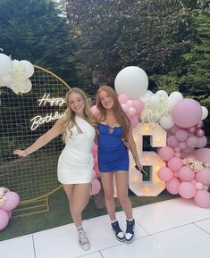 two young women posing in front of balloons