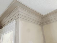 the corner of a room with white paint and molding on the wall above it