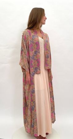 Take a step back in time to the romantic days of The Bloomsbury Group with this fine quality 1920s raw silk robe with a beautiful floral design. The colours are lovely, featuring pink, pale blue and white against a beige coloured ground. This robe was retailed by Selfridge in London (it is labelled to the inside of the neck). There are no ties or fastenings, this is meant to be worn loose and flowing for an unstructured  bohemian look. I love everything about this piece, it is just beautiful.  T Pink Vintage Long Kimono, Vintage Multicolor Kimono, Vintage Open Front Kimono For Summer, Vintage Open Front Summer Kimono, Bohemian Silk Kimono For Wedding, Vintage Pink Robe For Spring, Vintage Multicolor Silk Kimono, Long Pink Silk Robe, Bohemian Pink Kimono For Wedding