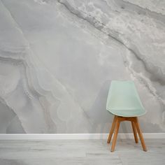 a chair sitting in front of a wall with a marble pattern on it's surface