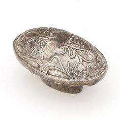 an old silver door knob with floral designs on the front and back side, isolated against a white background