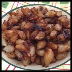 a bowl filled with cooked onions on top of a checkered tablecloth covered table