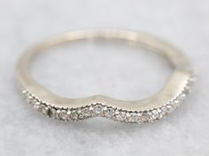 This elegant band is crafted from the finest white gold and set with shimmering diamonds. Its perfect shape ensures a comfortable fit and timeless beauty. Make a statement with this luxurious piece of jewelry.Metal: 14K White GoldGem: 26 Diamonds totaling .10 Carats, I1 in Clarity, H in ColorWidth of Band: 2.9 mmHeight off Finger: 2.7 mmRing Size: 6Marks: "14K" Stamped on the inside band Timeless Silver Diamond Bands, Elegant Diamond Bands With Pave Setting, Silver Diamond Eternity Band With Pave Setting, Silver Diamond Bands Fine Jewelry, Silver Diamond Bands In Fine Jewelry Style, Silver Diamond Bands With Single Cut Diamonds, Fine Jewelry Silver Diamond Bands, White Gold Diamond Bands With Brilliant Cut, Formal White Gold Eternity Band With Single Cut Diamonds