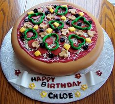 a birthday cake that looks like a pizza with toppings on it and the words happy birthday chose