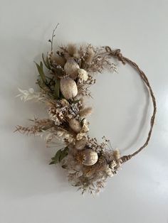 dried flowers are arranged on the side of a headband that is attached to a wall