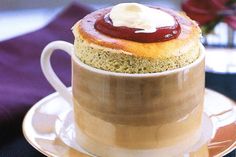 a cup with some kind of dessert in it on a saucer next to a flower