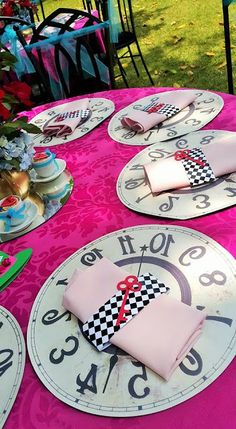 pink table cloth with black and white designs on clock plates, napkins and forks