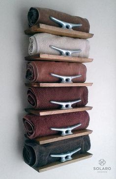 a wall mounted towel rack with five towels hanging from it's sides and four folded towels on each shelf