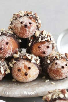 a pile of donuts covered in powdered sugar and nuts