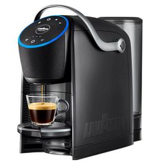 an automatic coffee maker with a cup of coffee in front of it on a white background