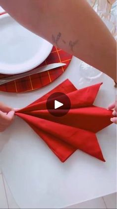 someone is cutting up some red napkins on a table