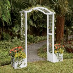 a white garden arch with flowers in it