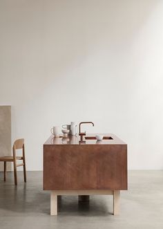 a kitchen sink sitting on top of a counter next to a wooden chair and table