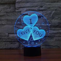 an illuminated glass ball with two hearts and the words i love you