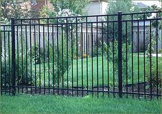 a black metal fence in the middle of a yard