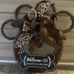 a welcome sign is attached to a wreath with leopard print ribbon and bow on the front door