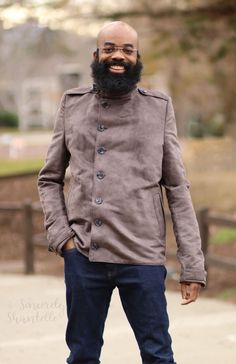 a man with a beard wearing a jacket and jeans