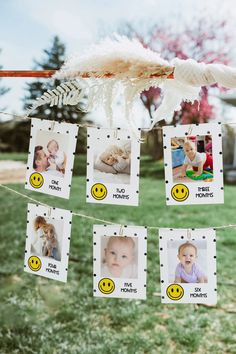 some pictures hanging from a clothes line with smiley faces and feathers attached to the clothesline