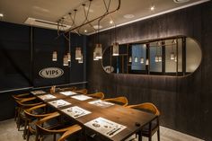 a restaurant with wooden tables and chairs in front of a round mirror on the wall