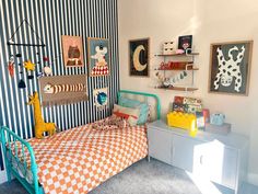 a child's bedroom decorated in blue, orange and white striped wallpapers