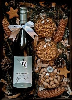 a bottle of wine and nuts in a gift box with pine cones, star shaped decorations