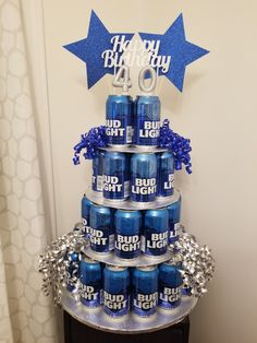 a birthday cake made out of blue and silver cans