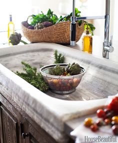 a bowl of vegetables sitting on top of a kitchen sink